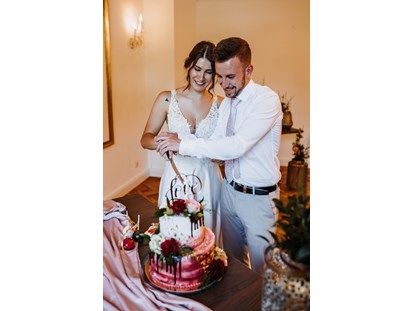Hochzeit - Preisniveau: moderat - Ainring - Torte anschneiden im Salon Freisaal - ARCOTEL Castellani Salzburg