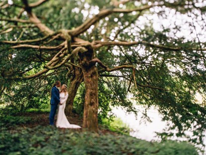Hochzeit - Art der Location: Scheune - Paar unter uralten Eiben im Park - Wasserburg Turow