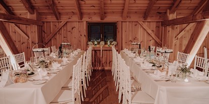 Hochzeit - Art der Location: Alm - Lange Tafeln in den Seitennischen der Tenne - Eventtenne - Hochzeits- & Veranstaltungslocation