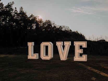 Hochzeit - Art der Location: Waldhochzeit - XXL-Leuchtbuchstaben "LOVE" als Fotohintergrund/Dekoelement - Eventlocation am Wald