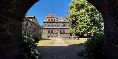 Hochzeit - Garten - Friedewald (Landkreis Altenkirchen) - Blick durch das Eingangstor in den Innenhof und das Schloss Friedewald - Schloss Friedewald (Westerwald)