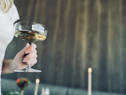 Hochzeit - Preisniveau: hochpreisig - Bad Hofgastein - Braut mit Champagner am Brauttisch - deck7 - Rooftop Haven Mountain Retreat