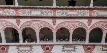 Hochzeit - Art der Location: ausgefallene Location - Lange Tafel in den überdachten Arkaden mit Blick in den Innenhof - Schloss Tratzberg