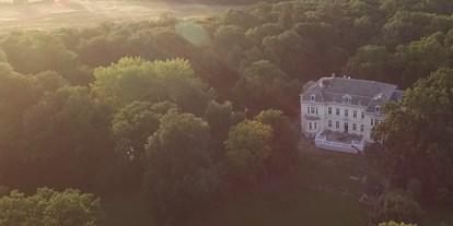 Hochzeit - Art der Location: Waldhochzeit - Luftaufnahme Schloss Schönfeld bei Sonnenuntergang - Eventschloss Schönfeld
