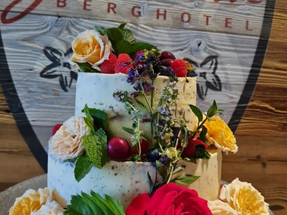 Hochzeit - Hochzeitsessen: Buffet - Naked Cake mit frischen Kräutern, Früchten und Blumen passend zum Brautstrauß. - Berghotel Gerlosstein